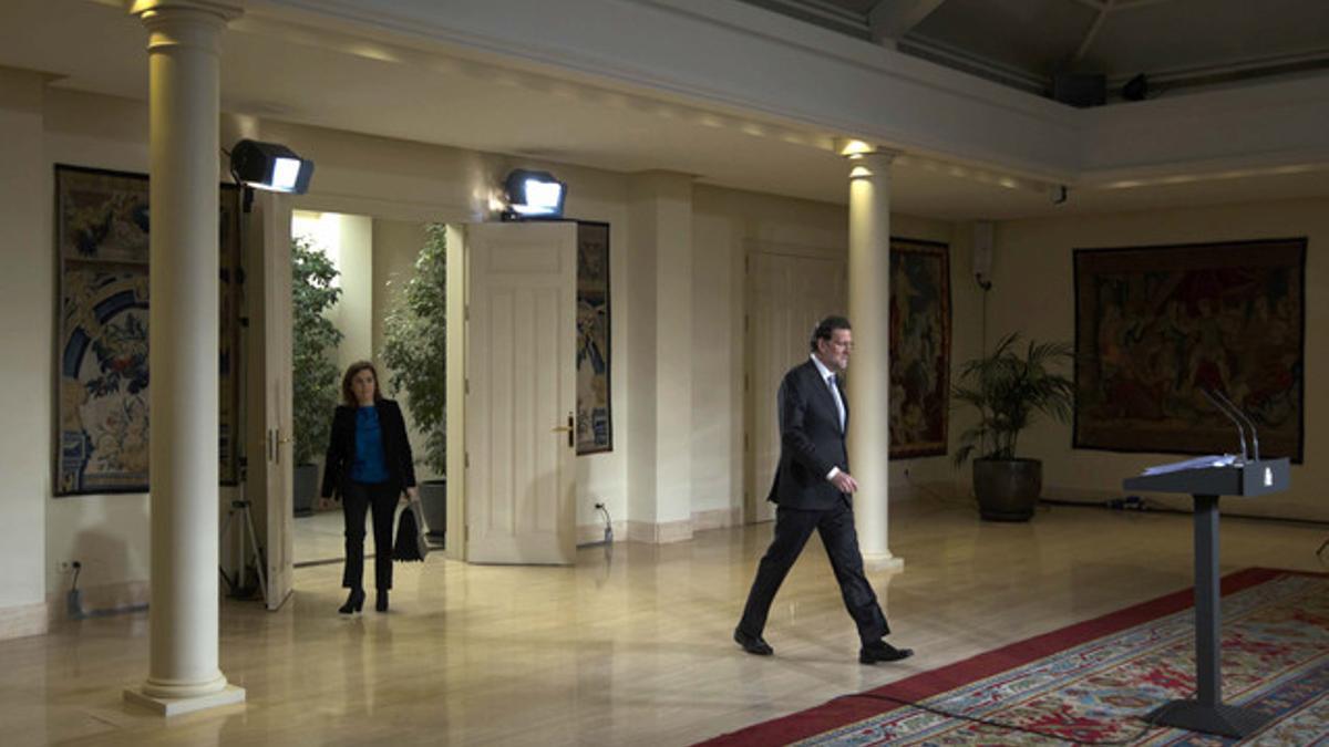 El presidente Rajoy llega, seguido de la vicepresidenta, Soraya Sáenz de Santamaría, a la rueda de prensa en el palacio de la Moncloa.