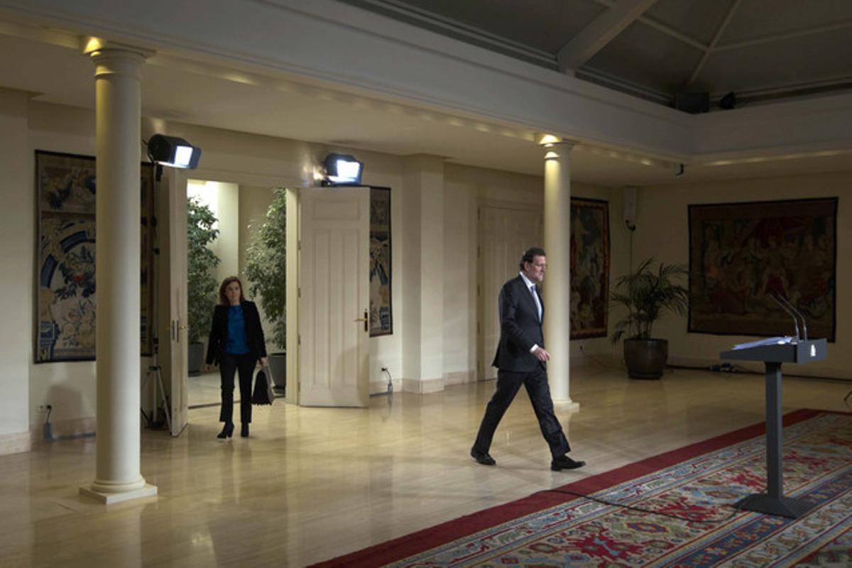 El presidente Rajoy llega, seguido de la vicepresidenta, Soraya Sáenz de Santamaría, a la rueda de prensa en el palacio de la Moncloa.