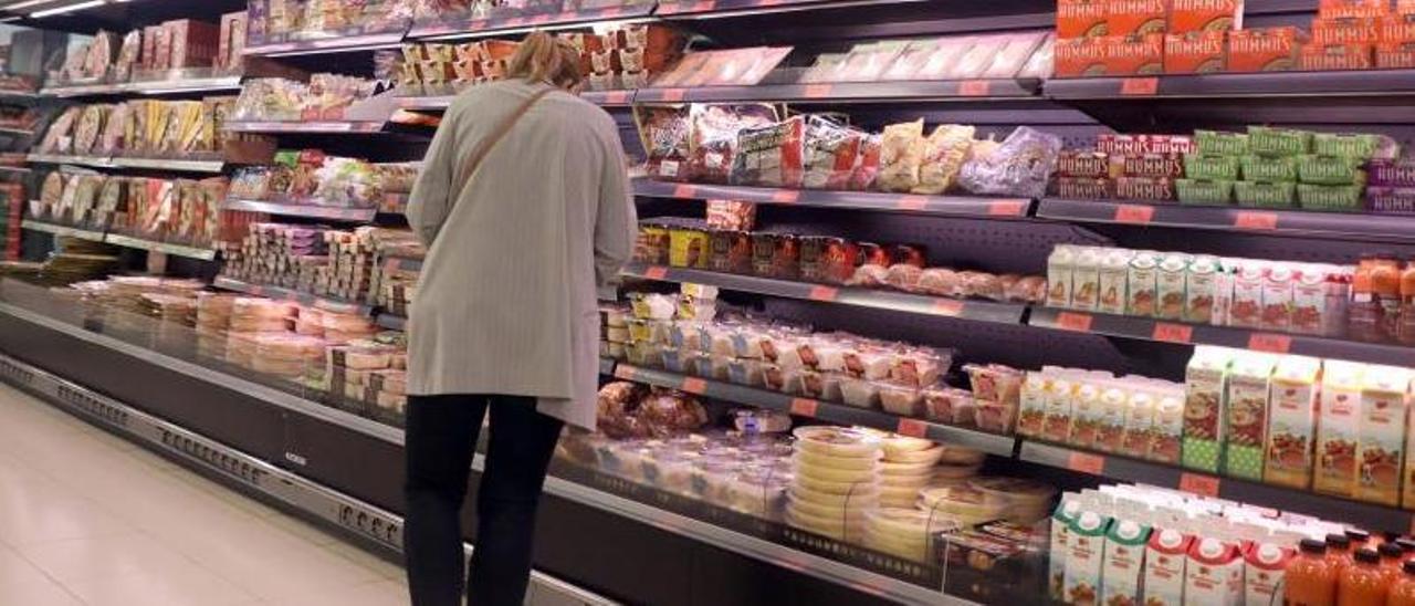 Una mujer comprueba los precios de plazo preparados en un supermercado de Santiago.