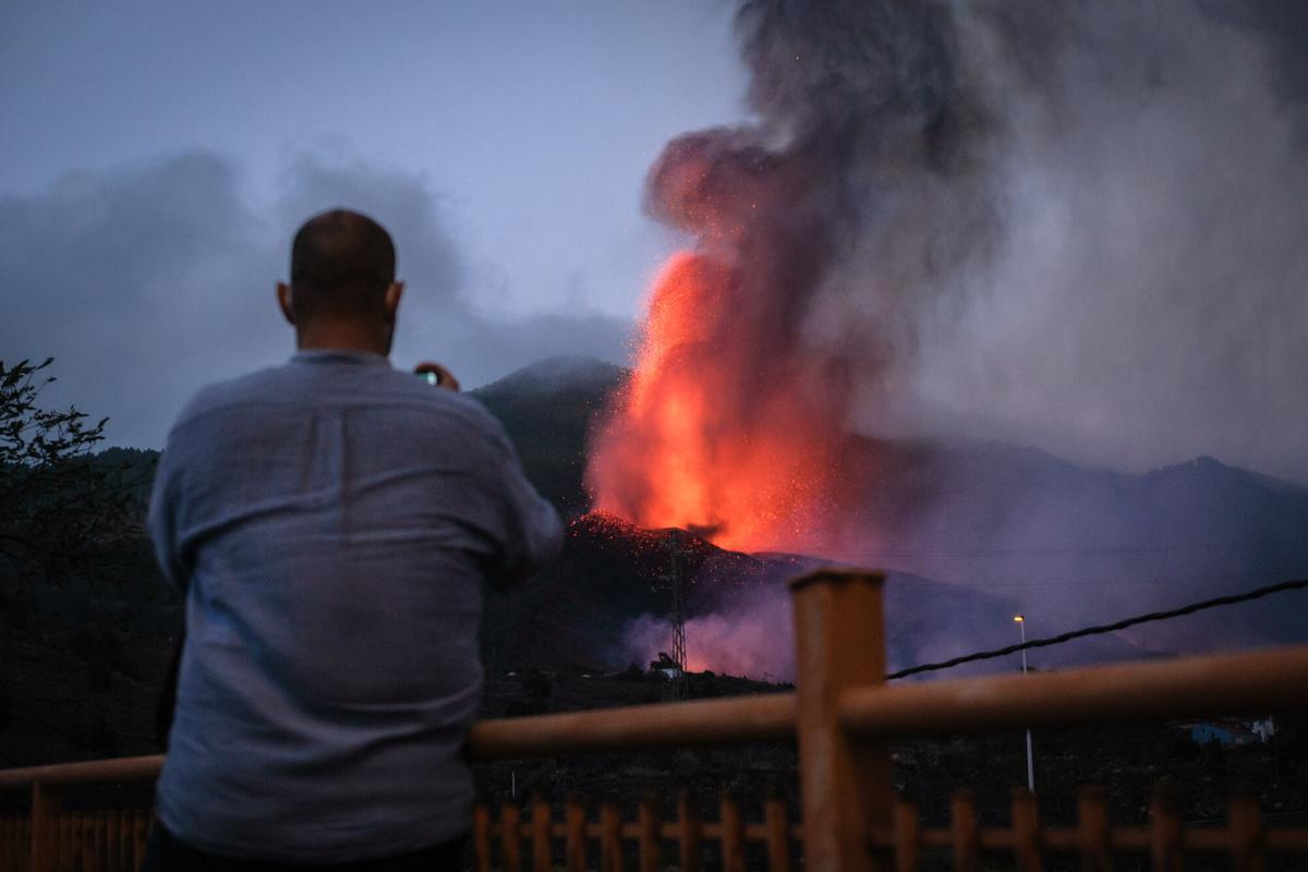 Un hombre fotografía al volcán Tajogaite durante la erupción de La Palma.