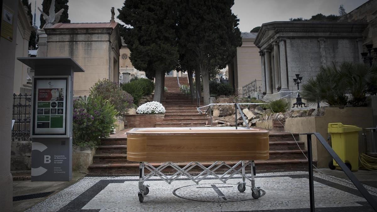 Servicios funerarios trasladan un ataúd al cementerio de Sant Gervasi.