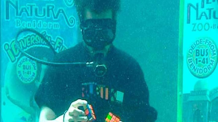 Resuelve dos cubos de Rubik rodeado de seis tiburones