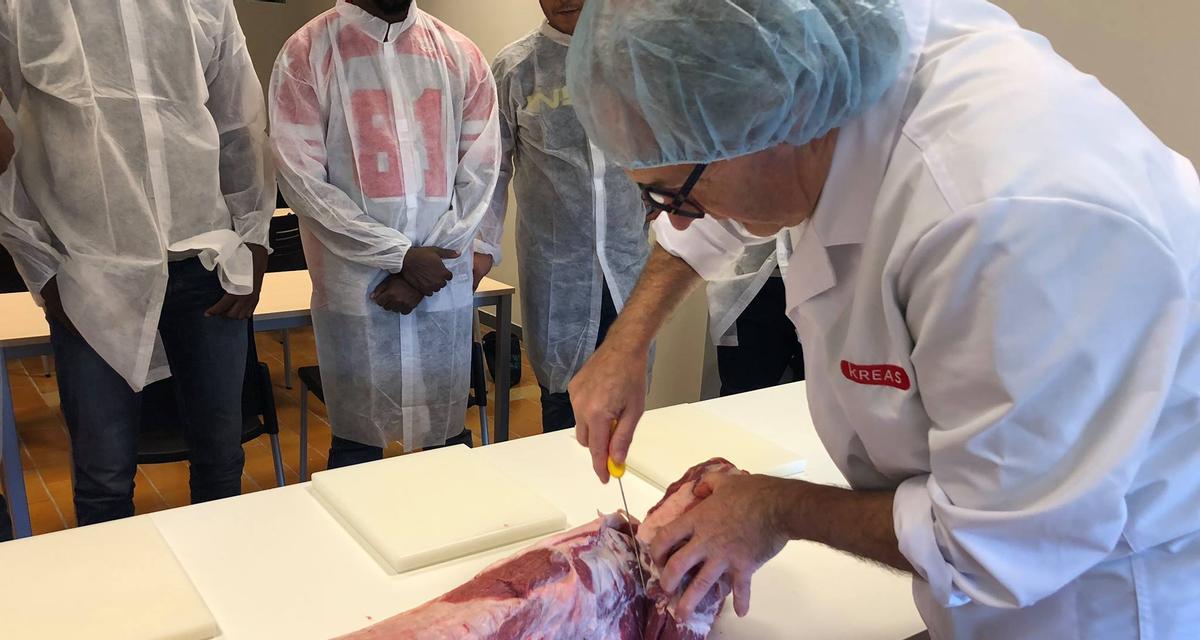 Un professor mostrant la tècnica per especejar carn als alumnes