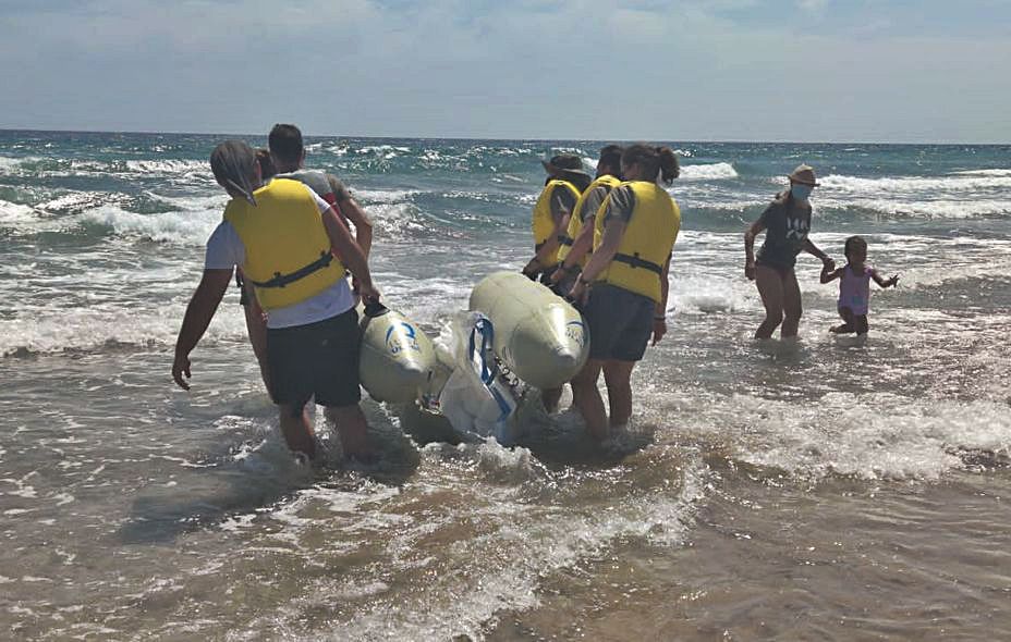 Voluntarios simulan reintroducir a un cetáceo varado a través de un pontón. 