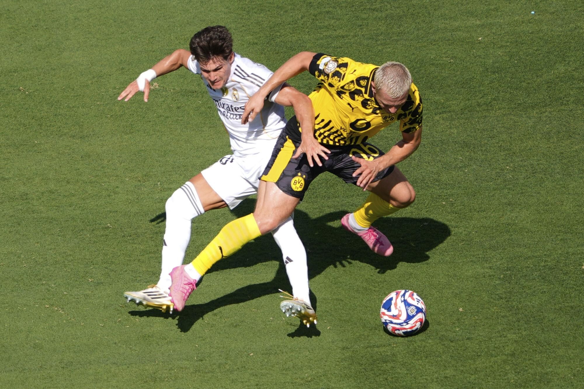Real Madrid's Fran Garcia, left, and Borussia Dortmund's Julian Ryerson fight for the ball during the Club World Cup quarterfinal soccer match between Real Madrid and Borussia Dortmund in East Rutherford, N.J., Saturday, July 5, 2025. (AP Photo/Pamela Smith)