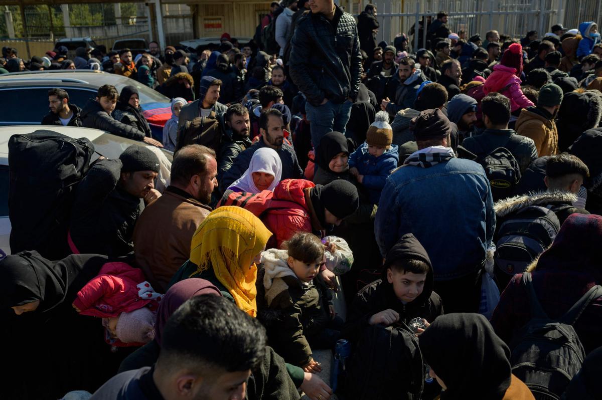 Los residentes sirios de la ciudad de Hatay esperan para cruzar la frontera entre Turquía y Siria después de que se vieron afectados por el terremoto de magnitud 7,8 que asoló la región hace casi dos semanas, en la puerta fronteriza de Cilvegozu