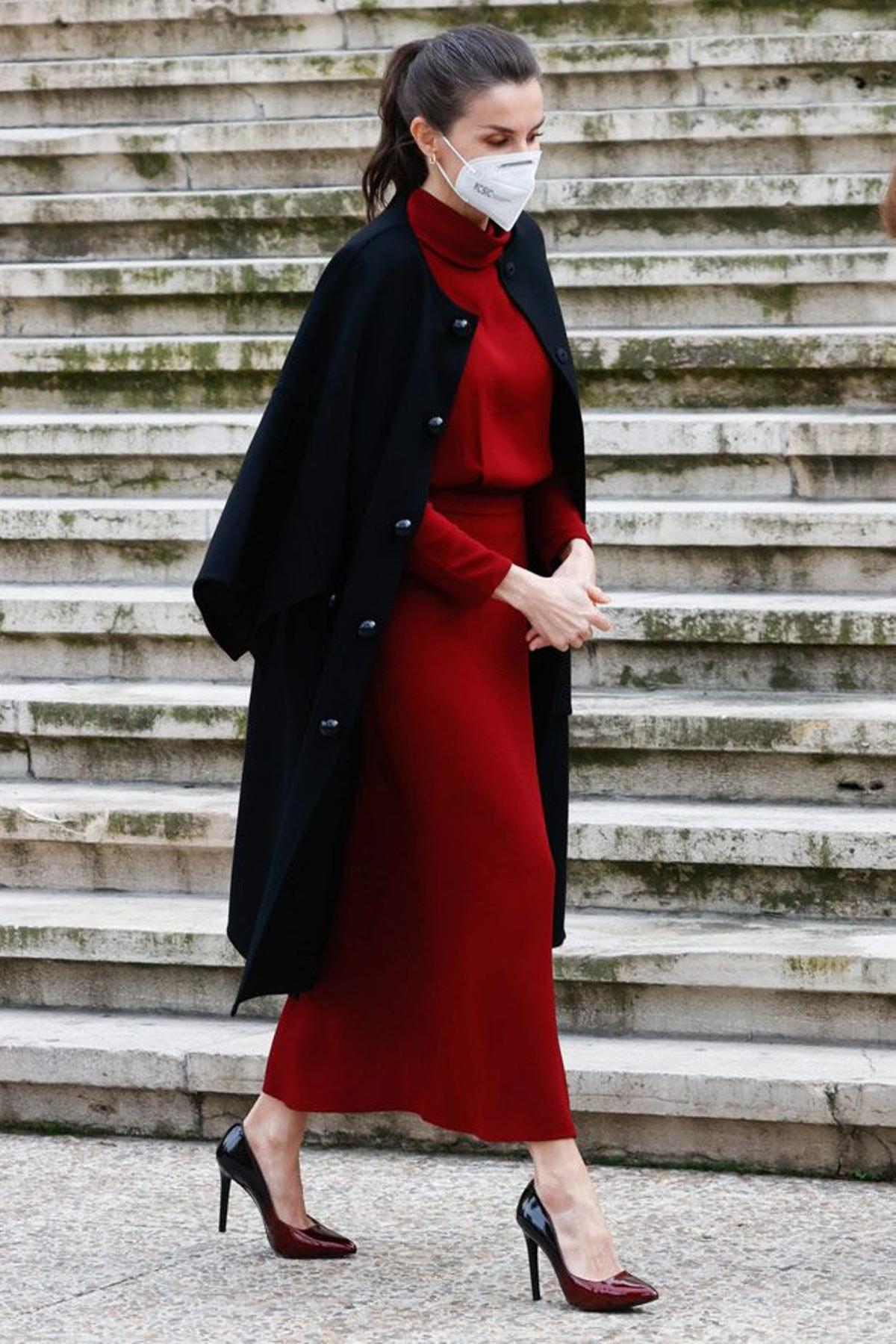 La reina, con vestido rojo oscuro y abrigo capa de Carolina Herrera