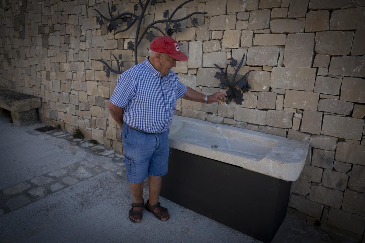 Josep Maria Bosch, vecino de Forés (Conca de Barbera) tratando de abrir el grifo una fuente cortada por la sequía.