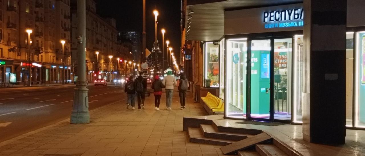 Un grupo de jóvenes camina por Moscú junto a establecimientos abiertos