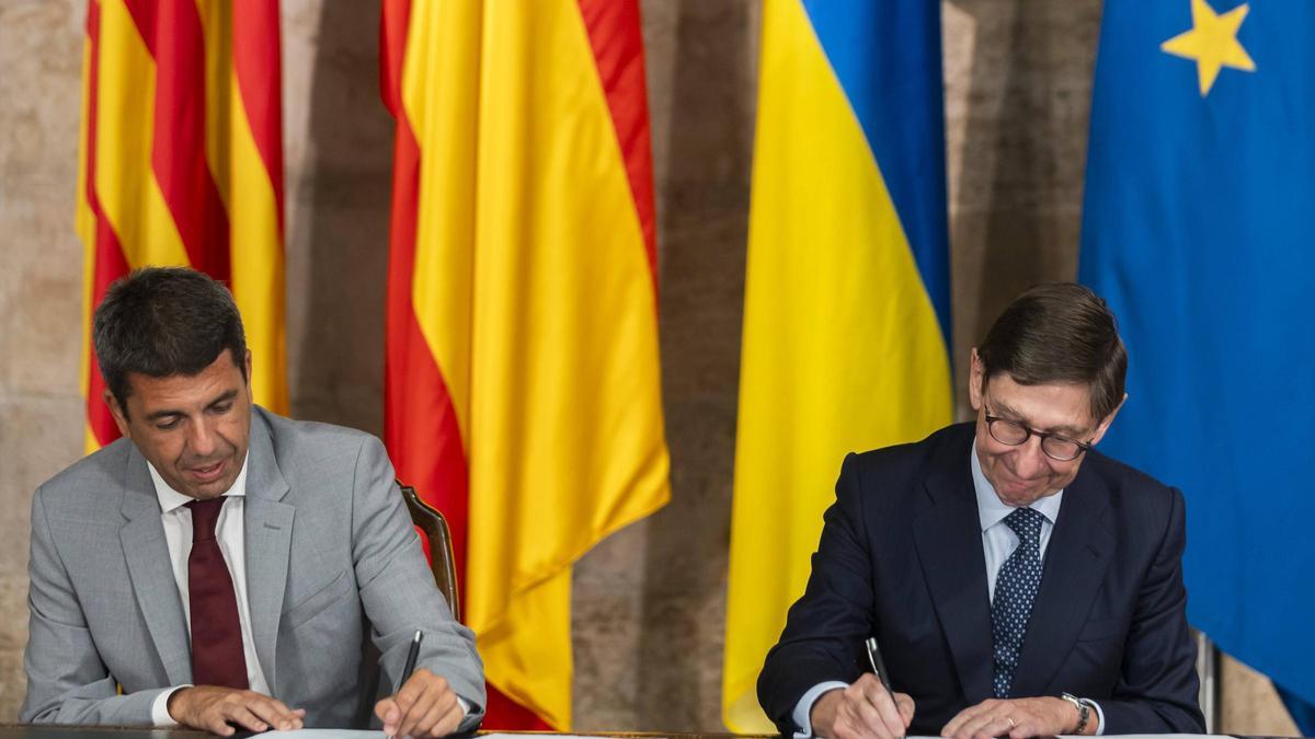 Carlos Mazón y José Ignacio Goirigolzarri, firmando el acuerdo, en el Palau.