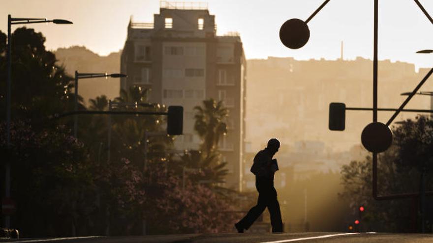 Un hombre pasea por Santa Cruz durante un episodio de calima.