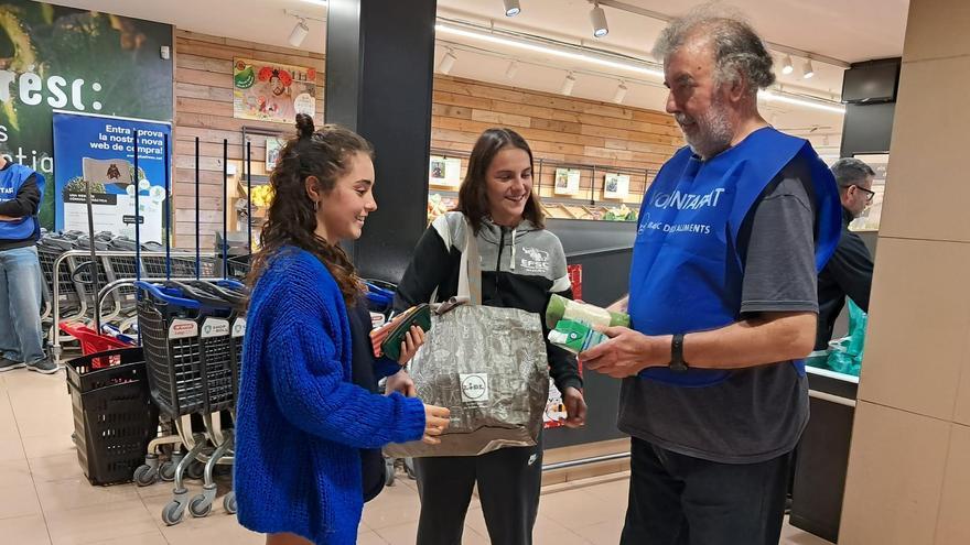 Emma Paquiot lliura els productes per al Gran Recapte al voluntari Ramon Closa, aquesta tarda, al supermercat Plusfresc