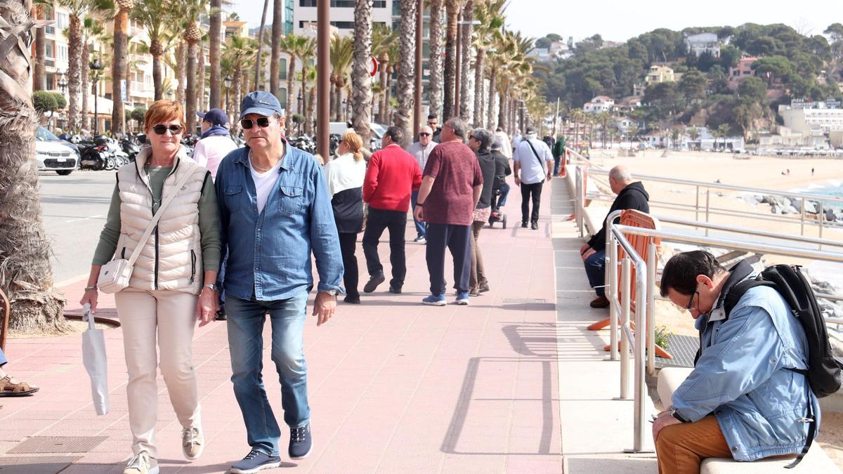 Alguns turistes passegen pel passeig marítim de Lloret de Mar a les portes de Setmana Santa