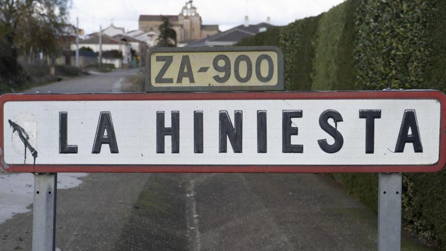 Cartel de La Hiniesta que da acceso al municipio de Zamora. Al fondo, la iglesia.