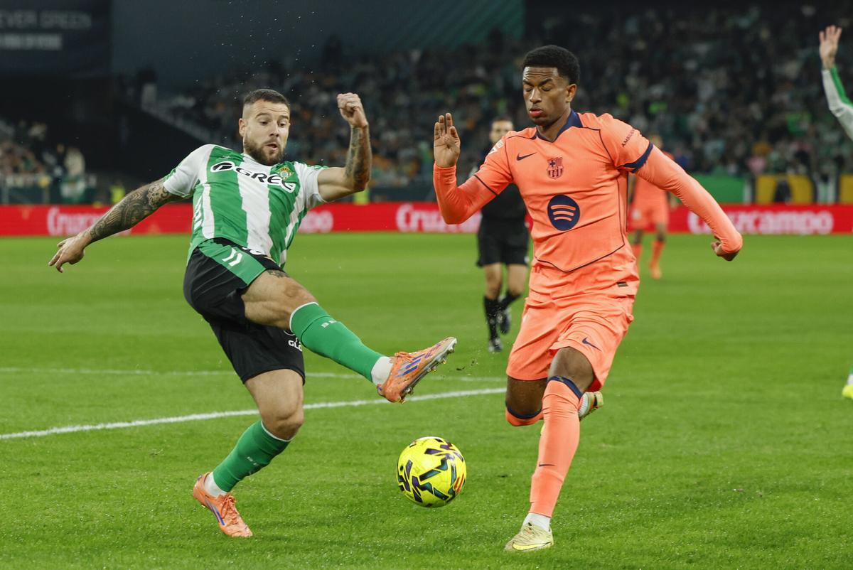 El defensa del Betis Aitor Ruibal y el defensa del Barcelona Alejandro Balde, durante el partido de la jornada 15 de LaLiga EA Sports entre el Betis y el Barcelona, este sábado en el estadio La Cartuja de Sevilla.- EFE/ Raúl Caro. (Barcelona) (Betis)