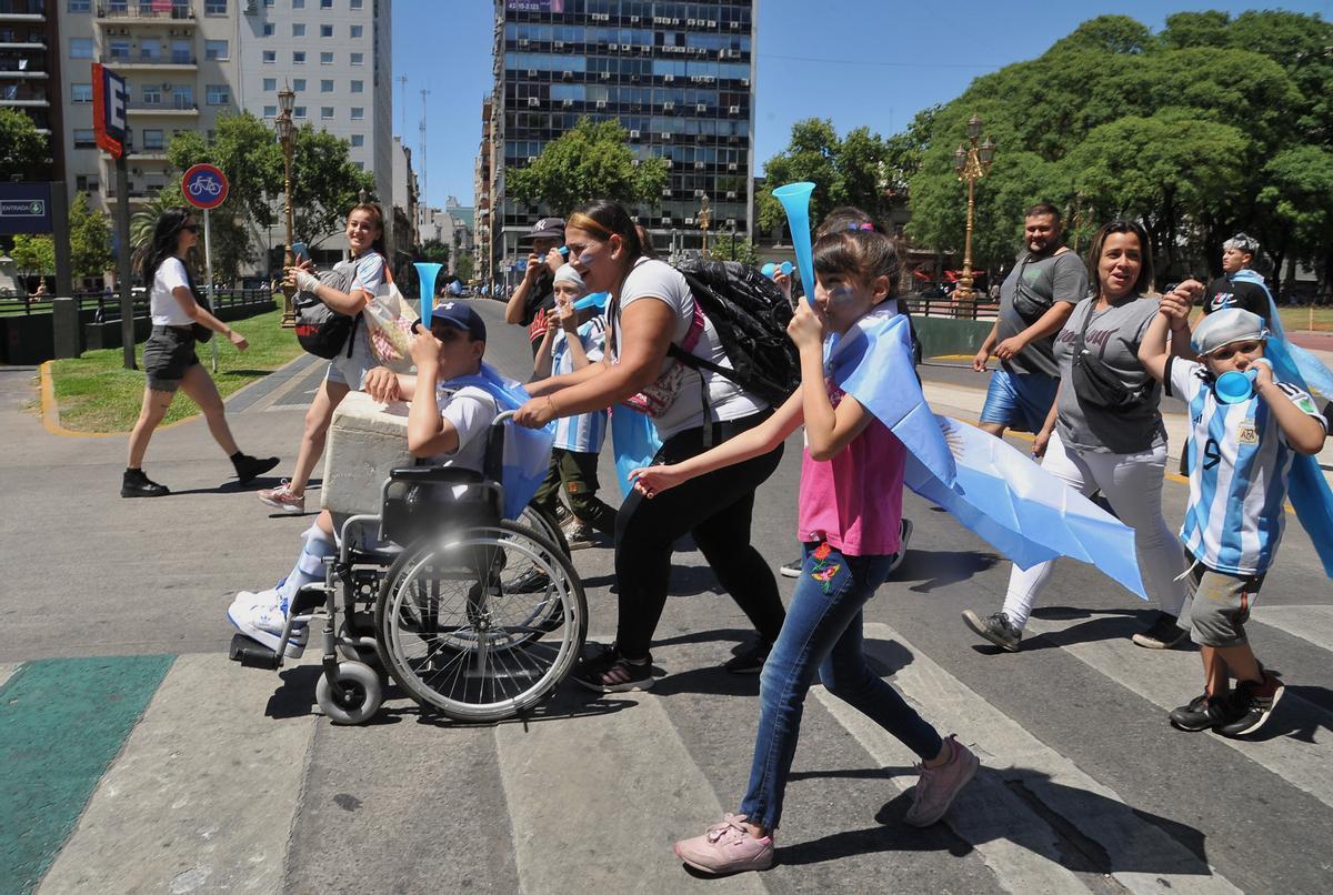 AME2020. BUENOS AIRES (ARGENTINA), 20/12/2022.- Seguidores de la selección de argentina animan hoy, durante la celebración de su triunfo en el Mundial de Qatar 2022 hoy, en una calle de Buenos Aires (Argentina). Argentina se proclamó campeona del mundo tras ganar en la tanda de penaltis (4-2) a Francia, después del empate 3-3 en los 120 minutos de juego. EFE/ Enrique García Medina