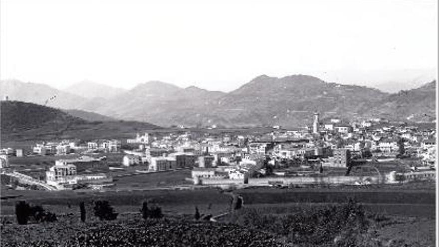 Olot vista des de Batet, amb la muralla i les torres de defensa a primer terme. Autor desconegut, 1895.