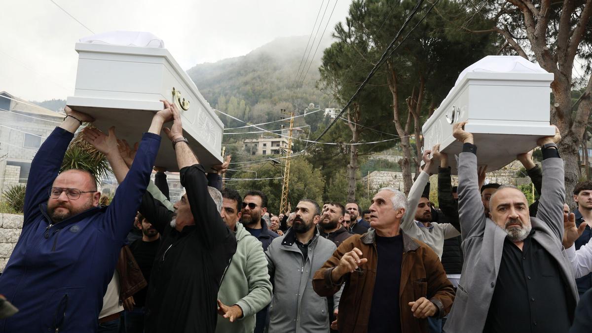 Los dolientes llevan los ataúdes del difunto Pierre Mouawad, dirigente del partido Fuerzas Libanesas, y de su esposa Flavia durante el cortejo fúnebre en la localidad de Yahchouch, al norte de Beirut, Líbano
