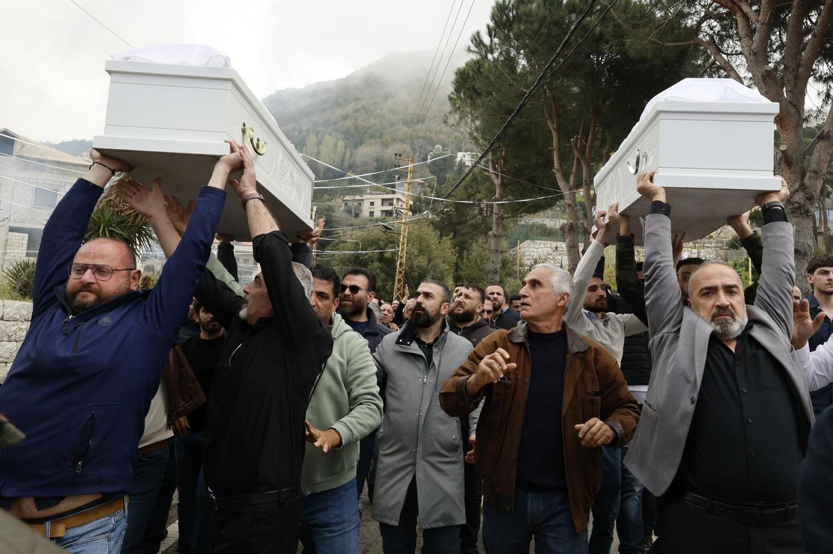 Los dolientes llevan los ataúdes del difunto Pierre Mouawad, dirigente del partido Fuerzas Libanesas, y de su esposa Flavia durante el cortejo fúnebre en la localidad de Yahchouch, al norte de Beirut, Líbano