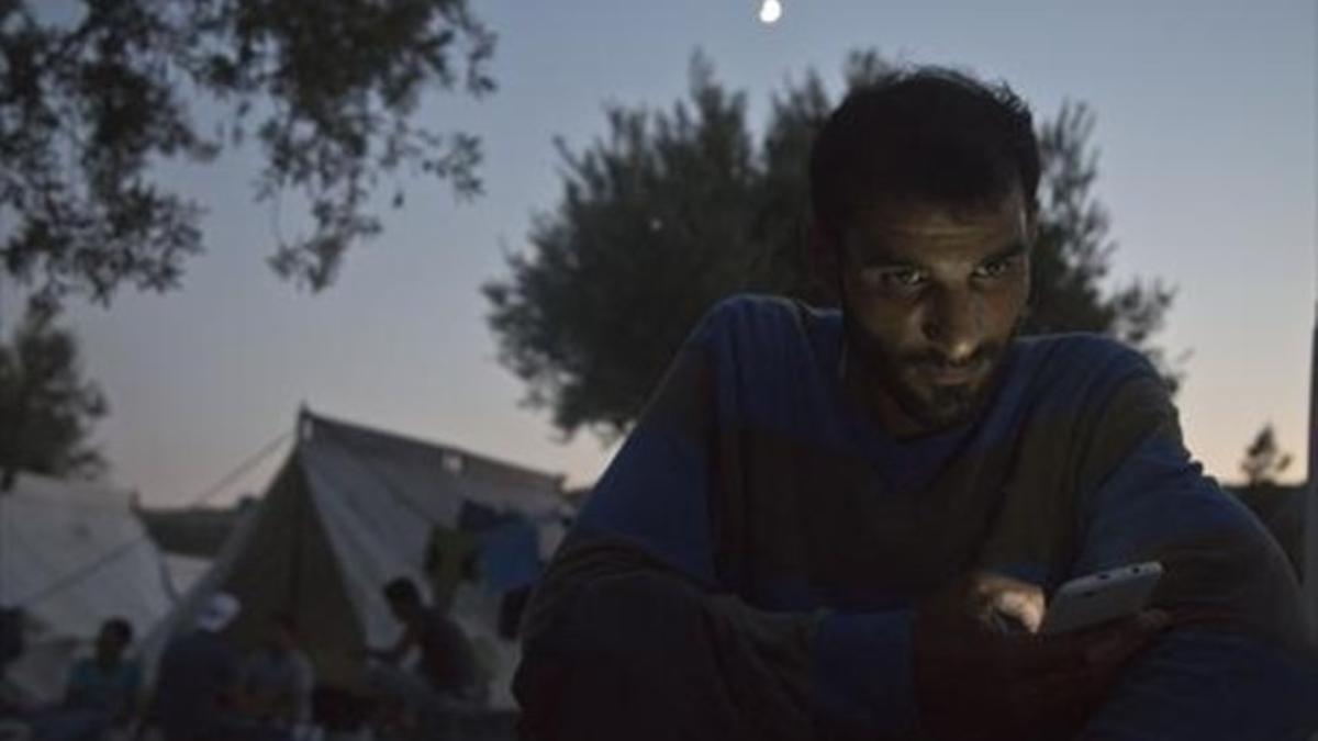 Un sirio, repasando los mensajes en su móvil en Aegean (Grecia).