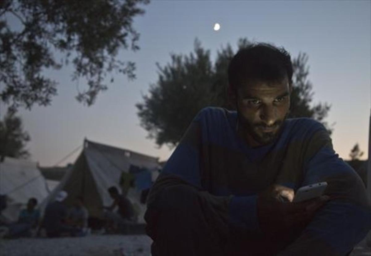 Un sirià, repassant els missatges al seu mòbil a Aegean (Grècia).