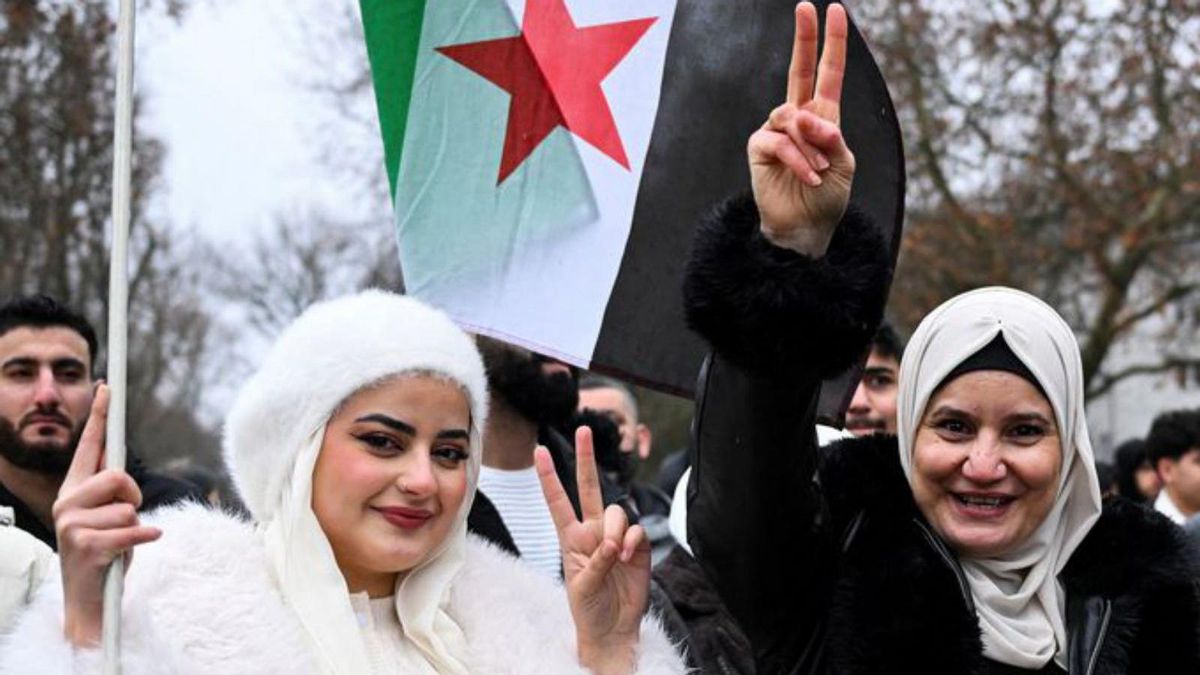 Dues dones celebren la caiguda del règim tirànic d’Assad en una manifestació a Berlín, diumenge. | ANNEGRET HILSE / REUTERS Dues dones celebren la caiguda del règim tirànic d’Assad en una manifestació a Berlín, diumenge. | ANNEGRET HILSE / REUTERS