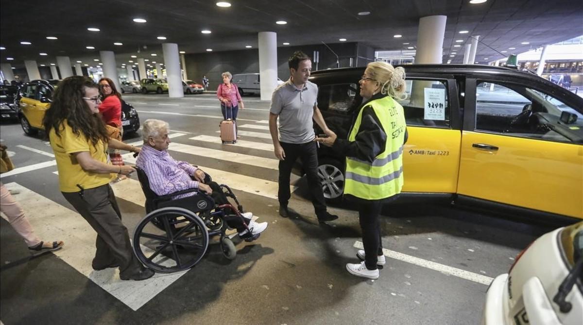 Un pasajero en silla de ruedas se sube a un taxi de servicios mínimos.