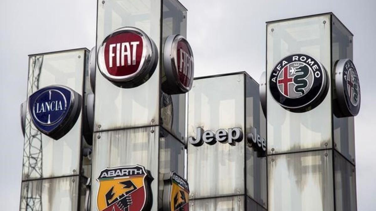 Logotipos de marcas de automóviles de la empresa Fiat Chrysler Automobiles (FCA) en un concesionario de Turín.
