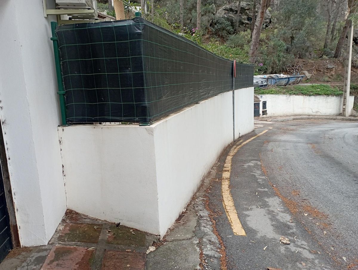 La acera no puede continuar en la avenida de San Antón y apenas cabe la señal de tráfico en este rincón de Pinares de San Antón..