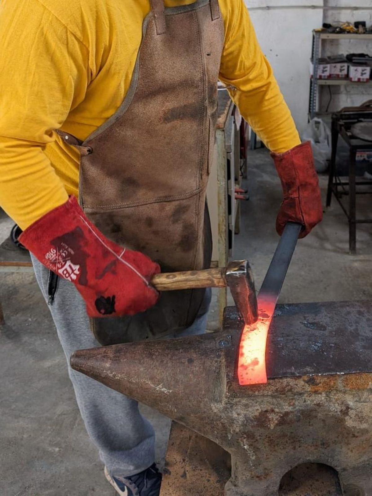 Un alumne del taller de ganiveteria forjant un ganivet.