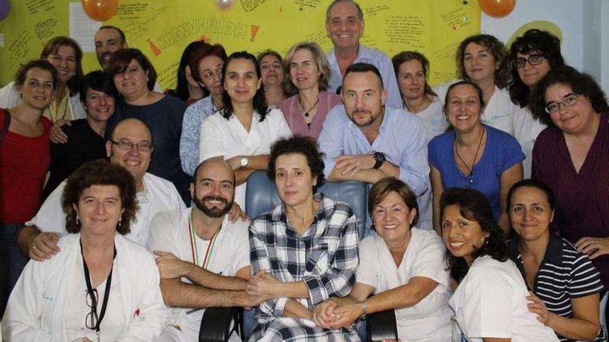 Teresa, en el centro de la foto con camisa a cuadros, junto al equipo médico y, tras ella, su marido Javier Limón, ayer en el Carlos III.  // Efe