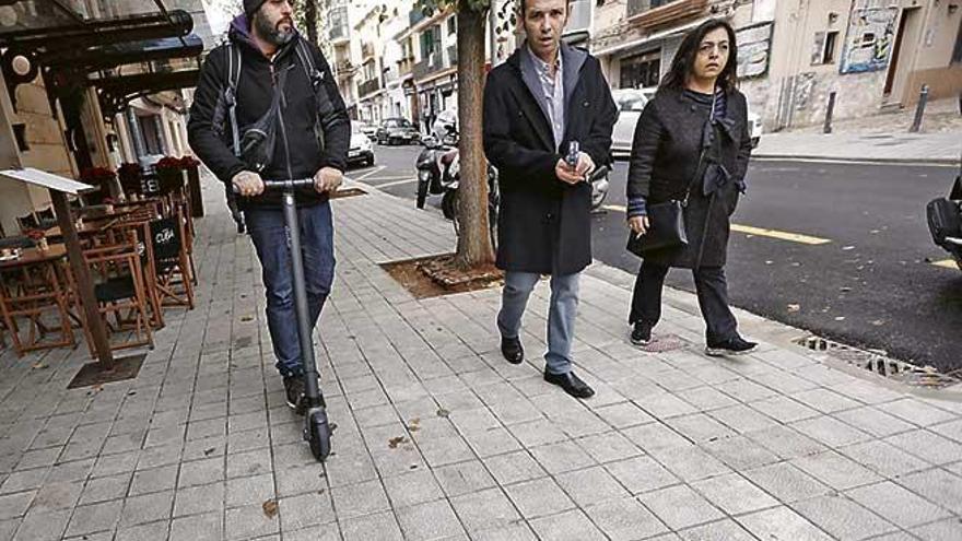 Un usuario de un patinete eléctrico circula por una acera de la calle Sant Magí.