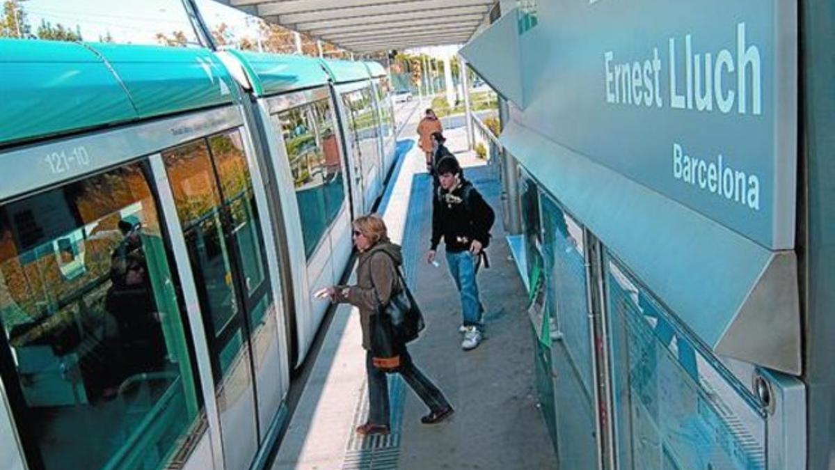 Unos pasajeros suben al Trambaix en la parada de Ernest Lluch, entre Les Corts y Collblanc.