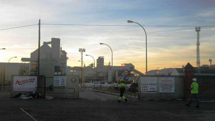 Dos operarios acceden a las instalaciones de la fábrica toresana de Azucarera.