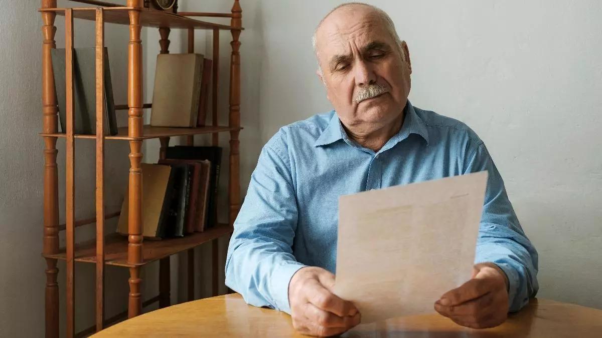 Un jubilado leyendo una carta, en una imagen de archivo