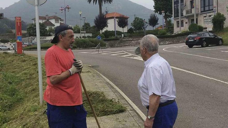 El interno Alberto Bulnes charla con un vecino mientras trabaja, ayer, en Ribera de Arriba.