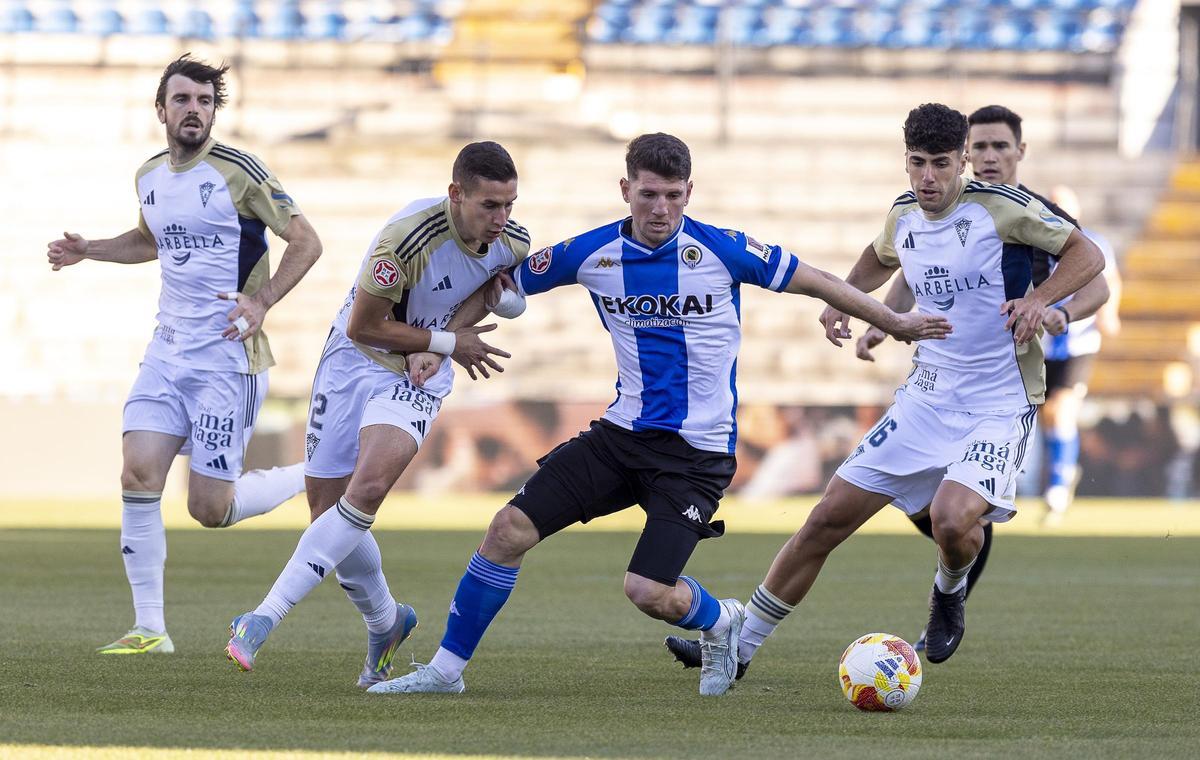 Alberto Toril, titular por primera vez como blanquiazul, protege la pelota rodeado de jugadores del Marbella.