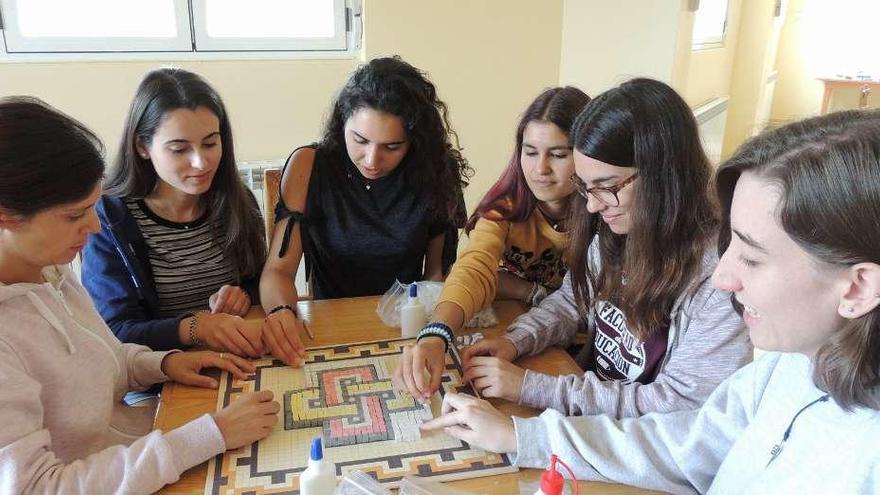 Un grupo de jóvenes jugando al parchís en el campamento.