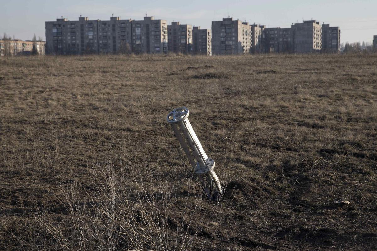 Emptied cluster munitions container is seen stuck in the ground outside apartment blocks in the town of Yenakiieve
