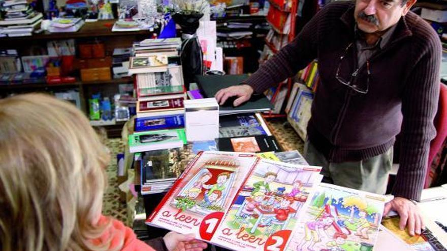 Luis González muestra libros de texto a una cliente, en la campaña escolar del curso pasado.