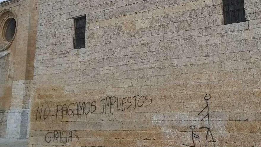 En la imagen, el texto y el dibujo que los vándalos han pintado en uno de los muros de la Colegiata.