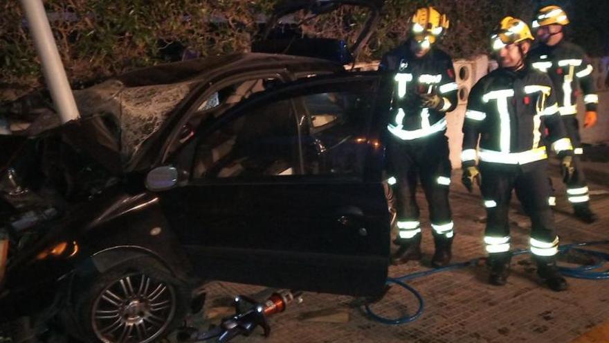 Los bomberos junto al vehículo tras el accidente.