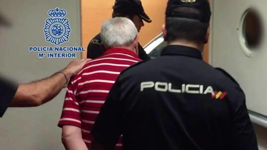 El médico custodiado por policías en la Comisaría Provincial de Alicante.