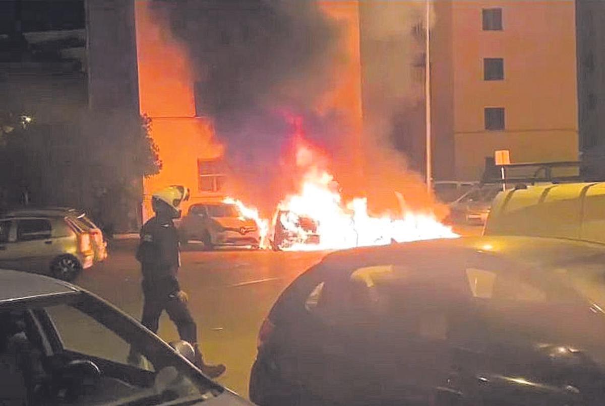 Un policía, frente a los coches incendiados de madrugada.