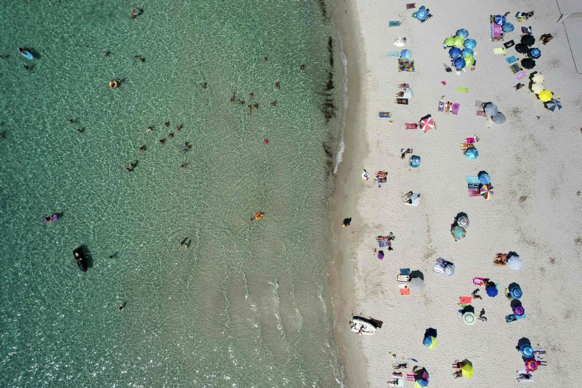 Vista aérea de turistas en la playa de Mare e Sole, en Pietrosella, en la isla francesa de Córcega, en un día de intenso calor.