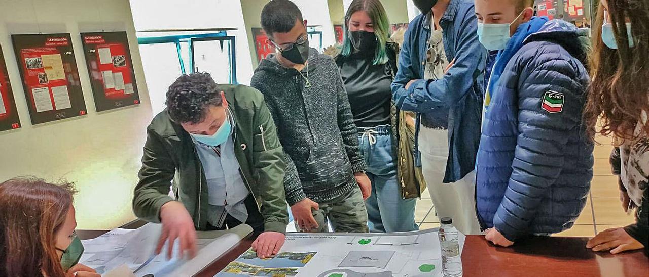 El alcalde de Laviana, mostrando el proyecto a varios miembros del Consejo de la Infancia, ayer, en el Cidan.