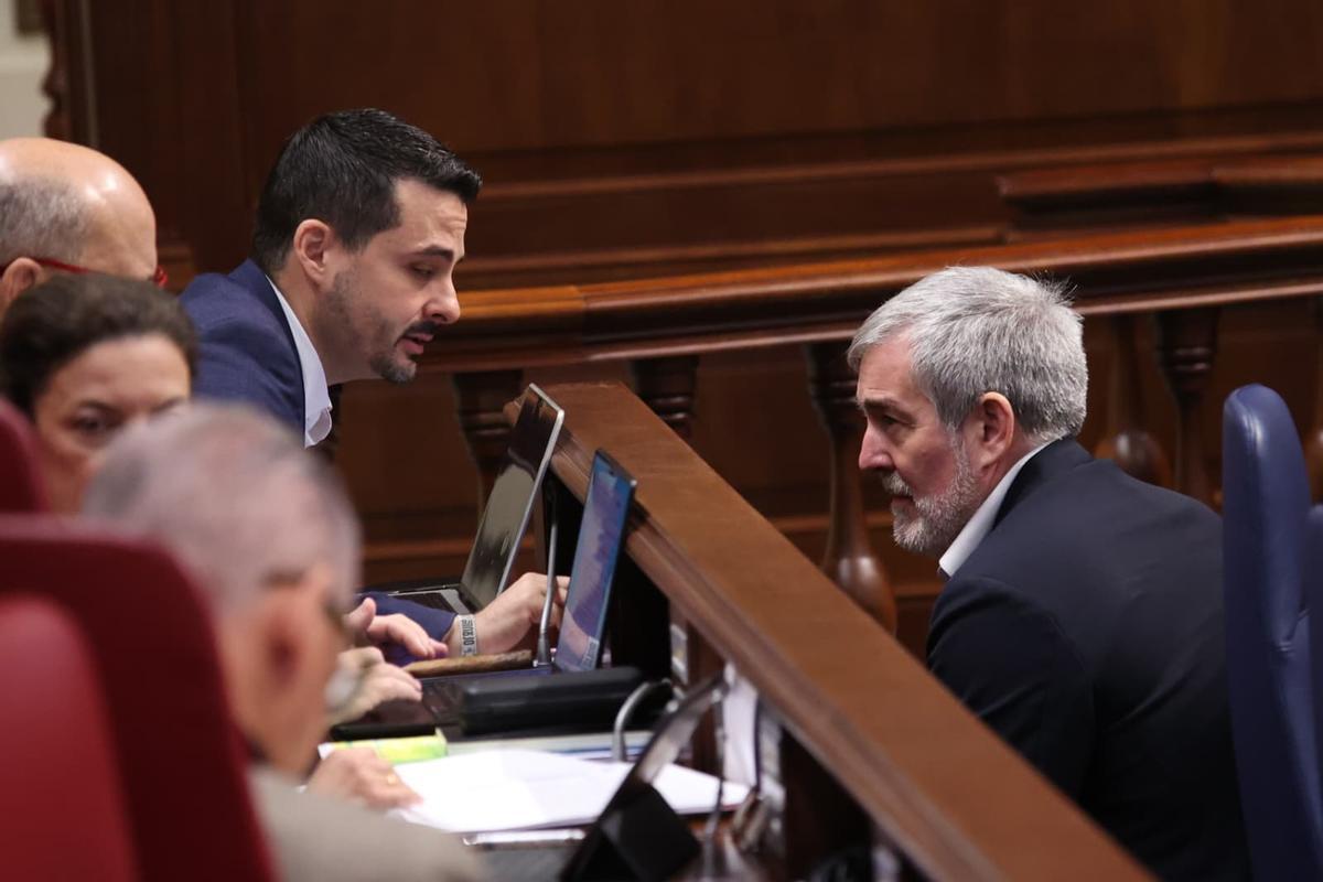 David Toledo (i) conversa con el presidente Fernando Clavijo en sus escaños del Parlamento.