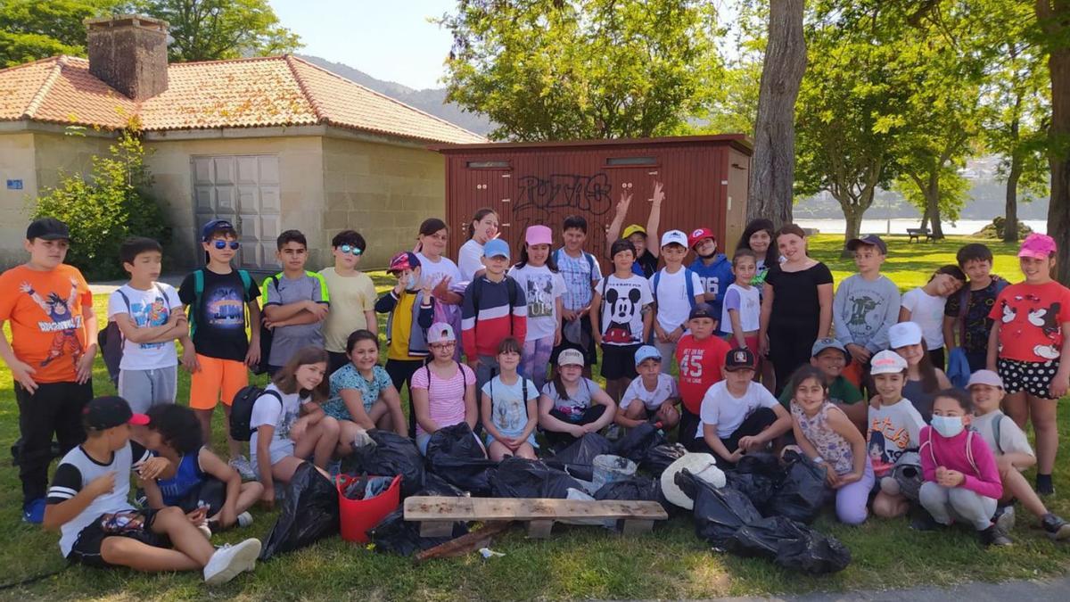 Los grupos de 3º y 4º de Primaria que ayer acudieron a limpiar la playa de Arnau, en Meira.   | // FDV