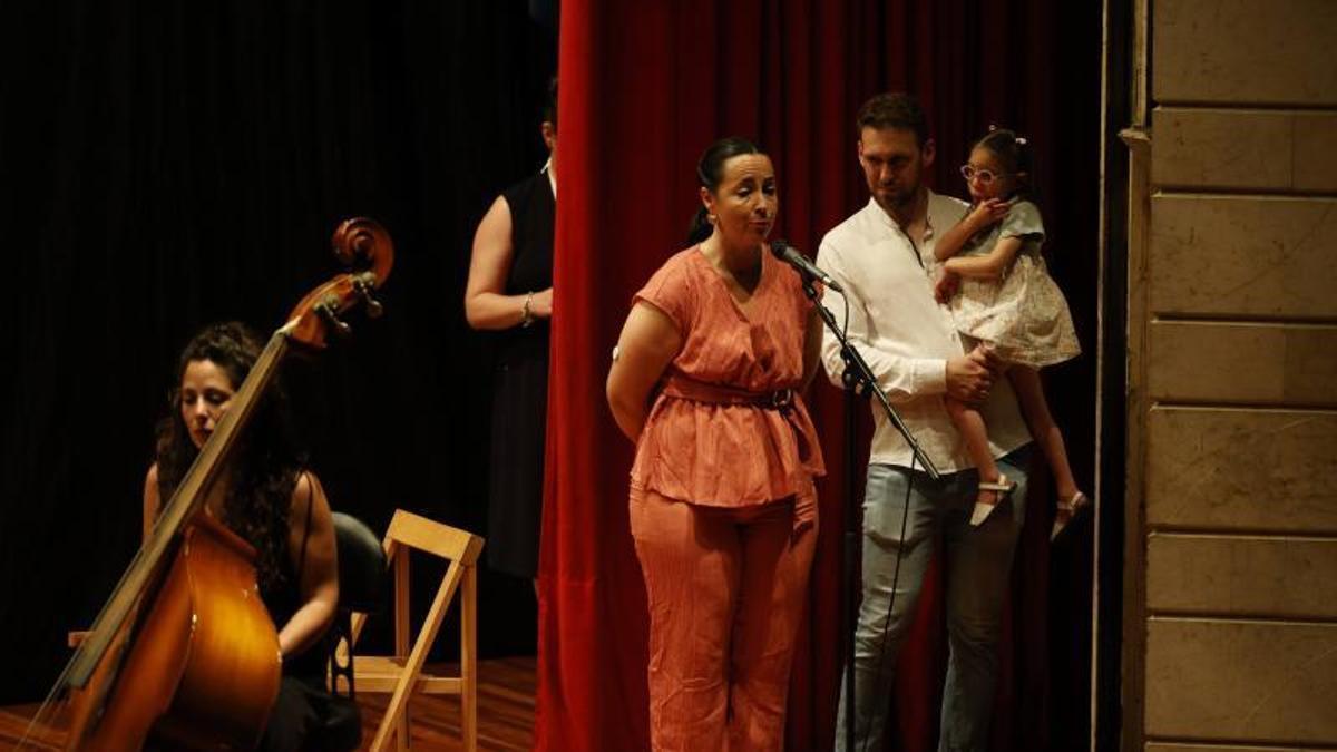 Cristina Arias y Santi Menor, con Inma en brazos, explican el síndrome de su hija al auditorio de la Casa de Cultura.