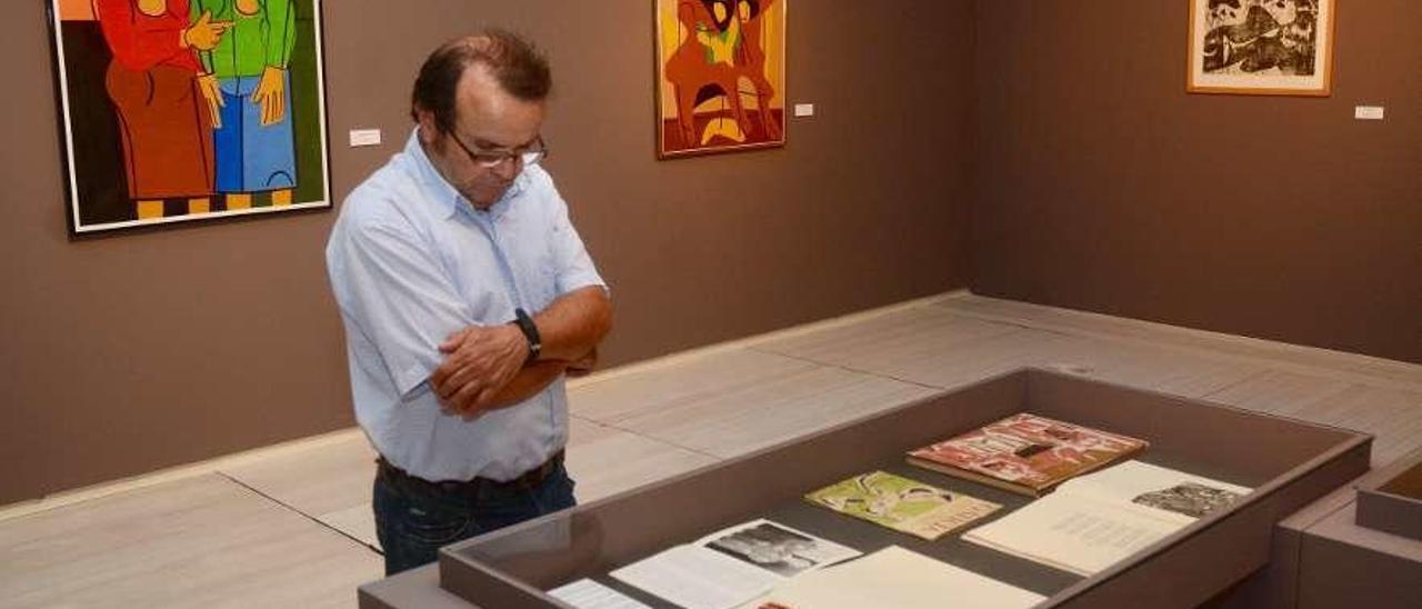 Un espectador observa materiales bibliográficos en la exposición dedicada a Seoane. // Rafa Vázquez